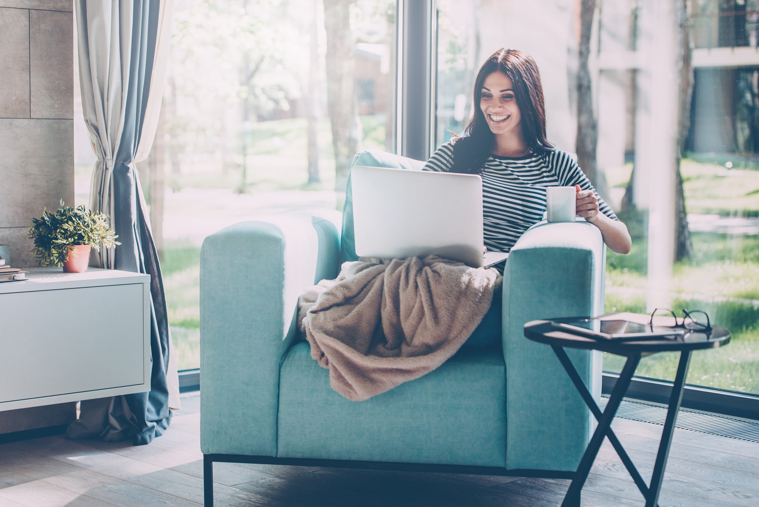 Woman looking up ways to borrow money during the pandemic on a laptop