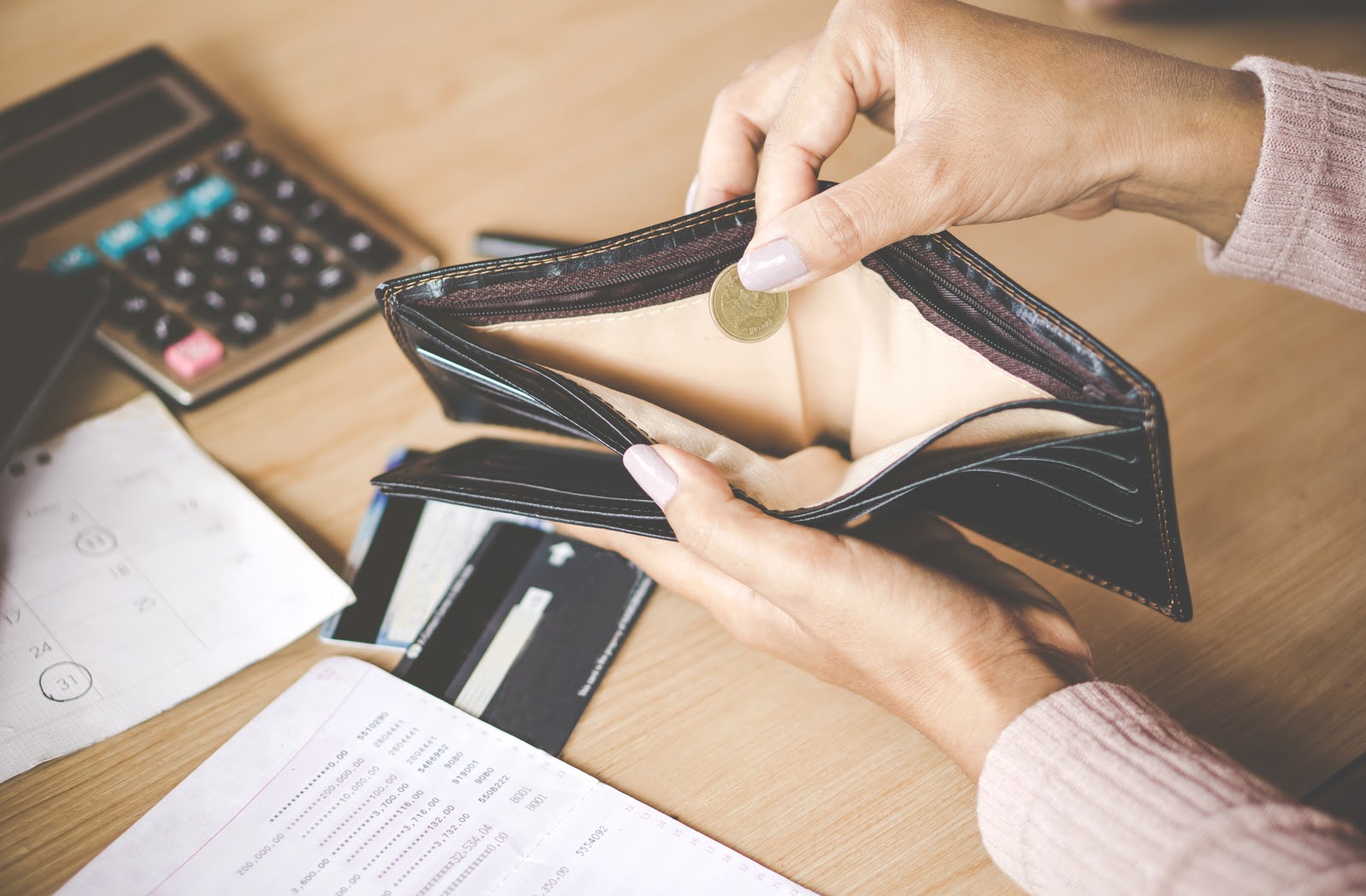 Woman looking into near-empty wallet, realizing she needs a loan.