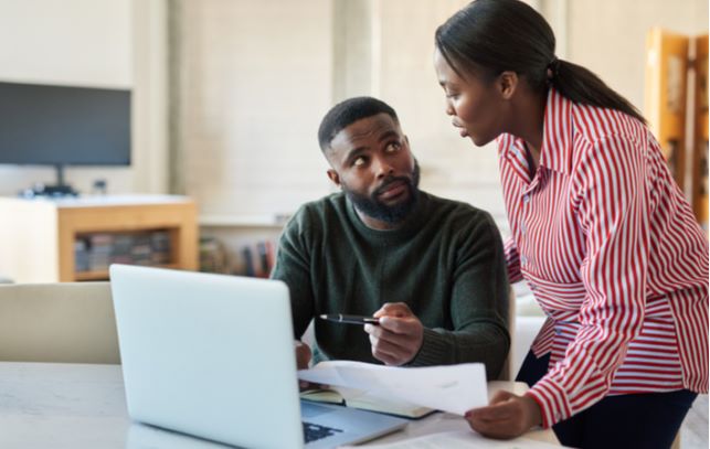 Young couple discussing together on ways to pay loan faster in living room