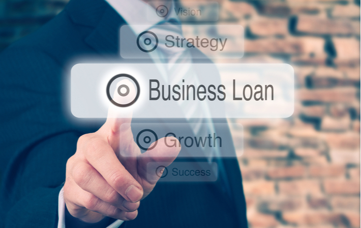 Businessman pressing a Business Loan concept button.