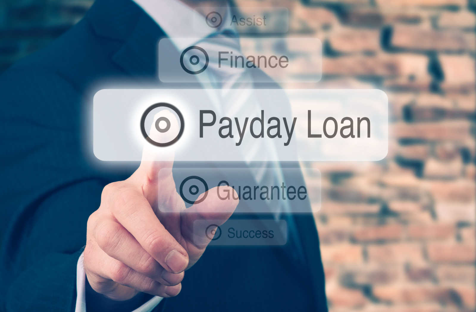 A man in a professional suit about to click on a digital 'payday loan' button.